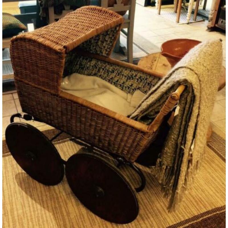 Oude brocante Kinderwagen van rotan met houten wielen