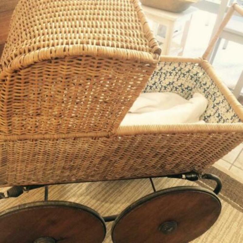 Oude brocante Kinderwagen van rotan met houten wielen
