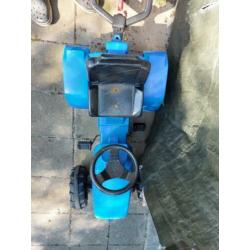 Blauwe tractor met aanhanger die omhoog kan.