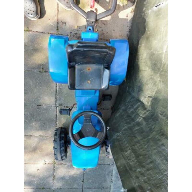 Blauwe tractor met aanhanger die omhoog kan.
