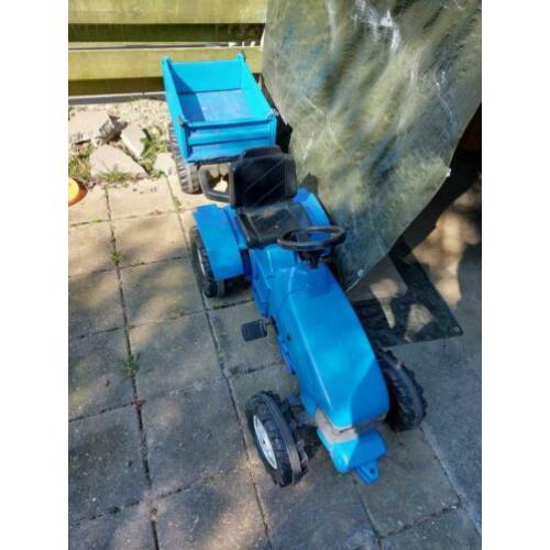 Blauwe tractor met aanhanger die omhoog kan.