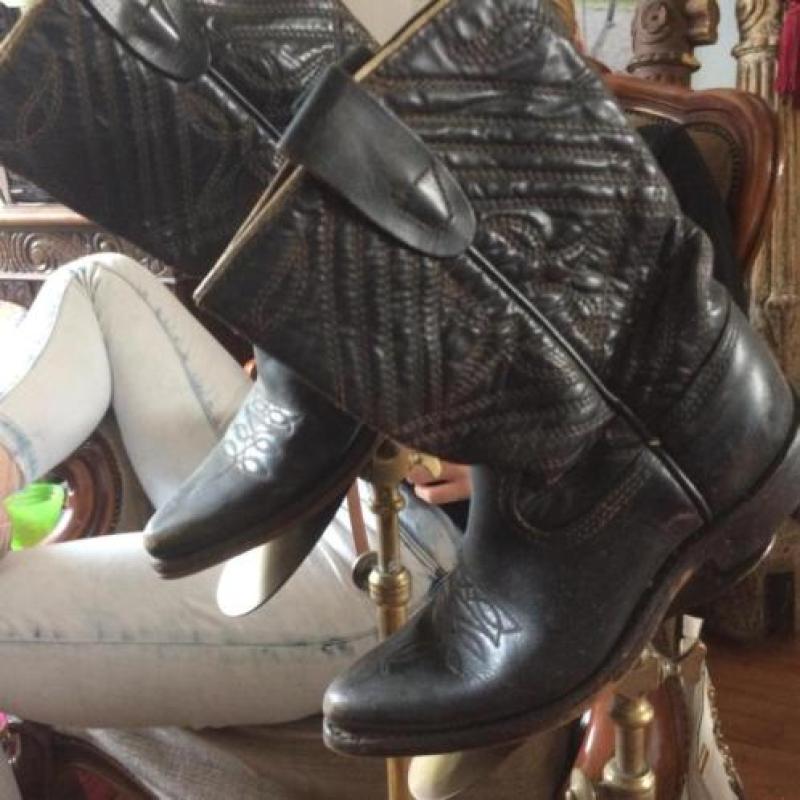 2kinder cowboy laarsjes op antieke laatzenstanders